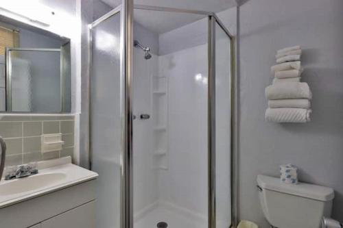 a bathroom with a shower and a toilet and a sink at Coastal Waters in New Smyrna Beach