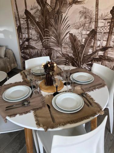 une table avec des assiettes blanches et des serviettes dessus dans l'établissement gite de saint lye, à Saint-Lyé
