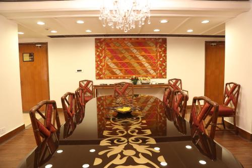 a dining room with a table and chairs and a chandelier at The Ashok, New Delhi in New Delhi