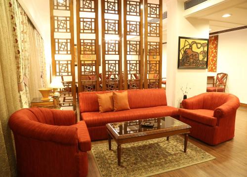 a living room with two orange couches and a coffee table at The Ashok, New Delhi in New Delhi