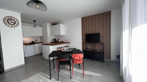 une cuisine avec une table noire et des chaises rouges dans l'établissement La Plaine St Denis, Paris Stade de France, à Saint-Denis