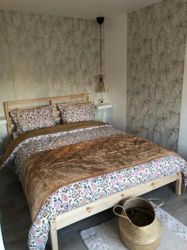 a bedroom with a large bed with a basket on the floor at gite de saint lye in Saint-Lyé