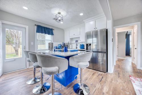a kitchen with a counter with stools and a refrigerator at Cozy Home with City Views in Columbus