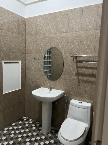 a bathroom with a sink and a toilet and a mirror at Mall Suites Hotel in Bangkok