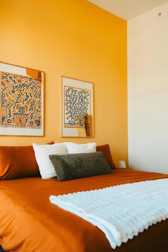 a bedroom with a large bed with orange walls at NEW Pause Penthouse Lofts -Downtown- Free Parking in Halifax