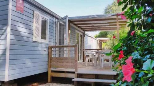 a porch of a house with a table and chairs at Camping 4 étoiles - eebaeh in Hyères