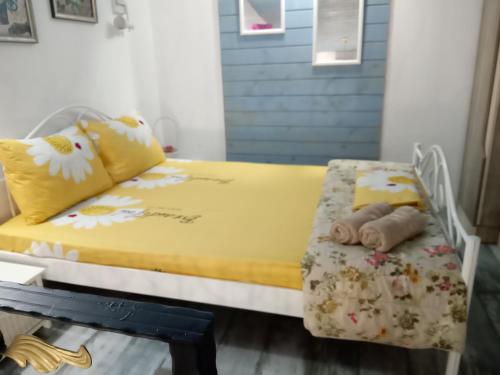 une chambre avec un lit jaune avec des fleurs dessus dans l'établissement Cosy House, à Sofia