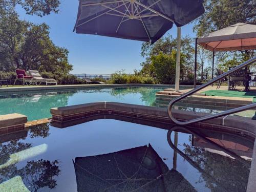 a swimming pool with an umbrella and a table at Yosemite Mountain Top Retreat Hilltop Manor Pool Spa in Mariposa