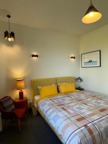 a bedroom with a bed with yellow pillows and a chair at Farmstay in Central Victoria in Ballan