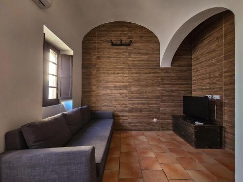 a living room with a couch and a flat screen tv at Casa na Vila T2 in Fuzeta