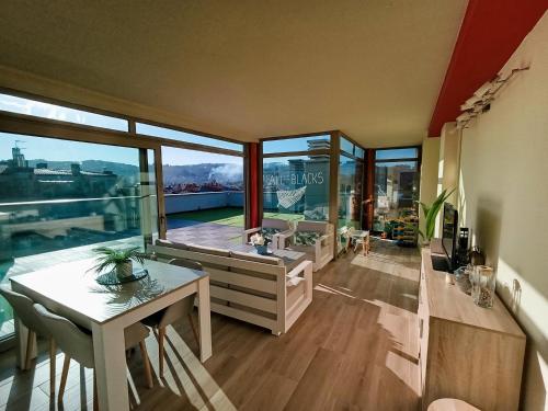 a living room with a table and a large window at Ático Chill-Out de lujo con piscina y garaje gratis in Vigo
