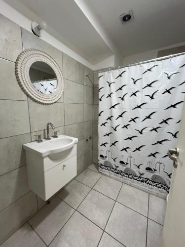 ein Badezimmer mit einem Waschbecken und einem Duschvorhang mit Vögeln in der Unterkunft Edificio Pacha in Santiago del Estero
