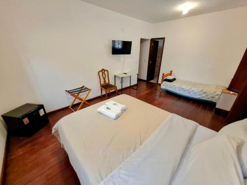 a hotel room with a bed and a tv at Casa Rosada seu refúgio na serra in Miguel Pereira