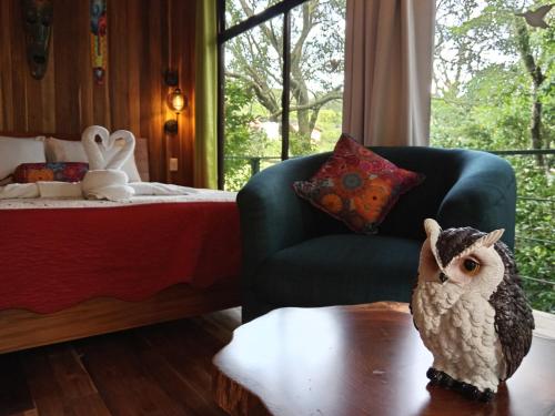 an owl statue sitting on a table in a bedroom at Jungle Living Tree Houses in Monteverde Costa Rica