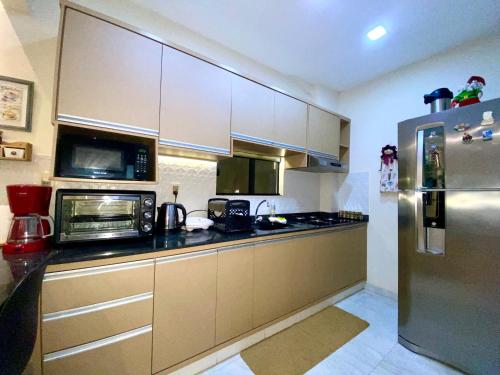 a kitchen with a stainless steel refrigerator and microwave at Apartamento RR Agradable y Moderno c 2 dormitorios y estacionamiento interno techado in Ciudad del Este