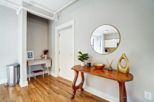 a room with a table and a mirror on a wall at The Republic Retreat Walk to Washington Park! in Cincinnati