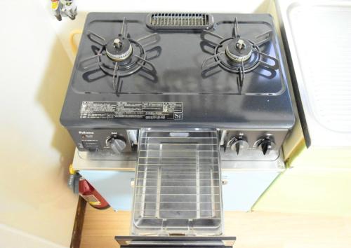 a black stove top oven sitting in a kitchen at Rooftop Haven 新小岩 in Tokyo