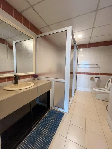a bathroom with a sink and a toilet at Riverbank Suites apartment in Kuching
