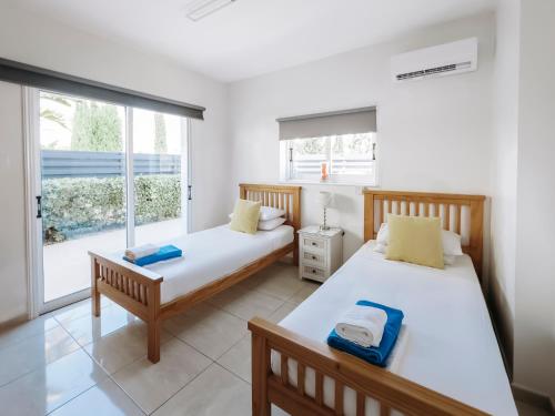 due letti in una stanza con finestra di Sunset Villa private complex heated pool a Ayia Napa