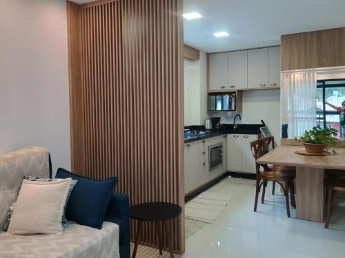 a living room with a couch and a table and a kitchen at Refúgio em Palmas in Governador Celso Ramos