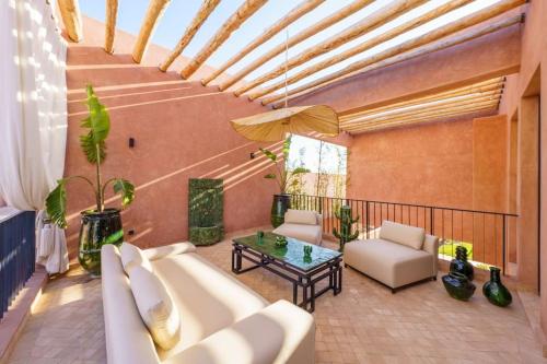a living room with a couch and a table at Dar Al Jenna - Villa de luxe avec piscine privée in Marrakech