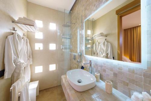 a bathroom with a sink and a shower with a mirror at Dar Al Jenna - Villa de luxe avec piscine privée in Marrakech