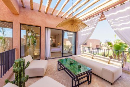 a living room with a couch and a table at Dar Al Jenna - Villa de luxe avec piscine privée in Marrakech