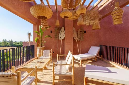 a porch with chairs and rattan chairs and chandeliers at Dar Al Jenna - Villa de luxe avec piscine privée in Marrakech