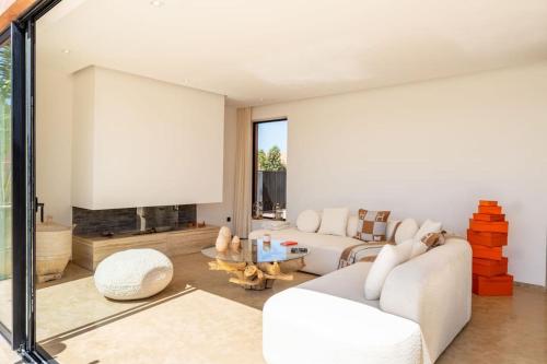 a living room with two white couches and a fireplace at Dar Al Jenna - Villa de luxe avec piscine privée in Marrakech
