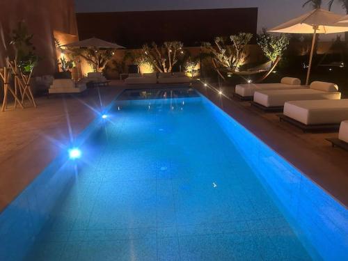 a swimming pool at night with blue lights at Dar Al Jenna - Villa de luxe avec piscine privée in Marrakech