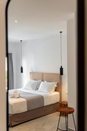 a bedroom with a large bed with white pillows at Cavo Piso Livadi in Piso Livadi