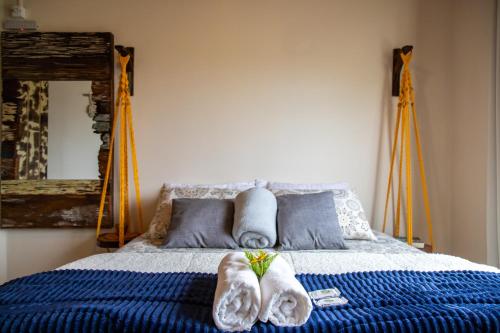a bedroom with a bed with towels on it at Apartamentos exclusivos e equipado com varanda ou terraço com Pôr do sol, cozinha privativa, Wi-Fi 600MBs, a 700m da praia de Itapirubá e 1km da BR-101 in Imbituba
