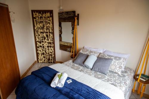 a bedroom with a bed with blue sheets and pillows at Apartamentos exclusivos e equipado com varanda ou terraço com Pôr do sol, cozinha privativa, Wi-Fi 600MBs, a 700m da praia de Itapirubá e 1km da BR-101 in Imbituba