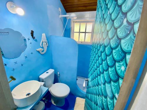 a blue bathroom with a fish mural on the wall at Gruta da Sereia Suítes Ubatuba in Ubatuba
