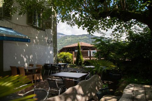 eine Terrasse mit Tischen und Stühlen und ein Gebäude in der Unterkunft Au Bord Du Lac in Därligen