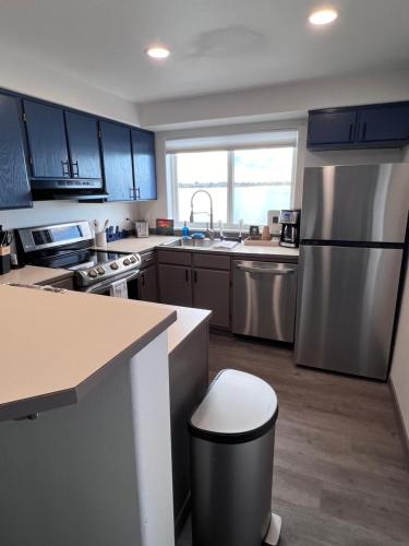 a kitchen with blue cabinets and a stainless steel refrigerator at Prime Lakefront on Moses Lake in Moses Lake