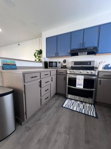 a kitchen with blue cabinets and a stove top oven at Prime Lakefront on Moses Lake in Moses Lake