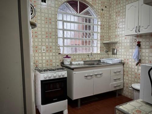 una piccola cucina con piano cottura e finestra di Ubatuba Casa linda na Praia do Lázaro a Ubatuba
