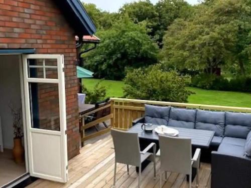 a patio with a blue couch and chairs on a deck at 5 star holiday home in MOLLÖSUND in Mollösund