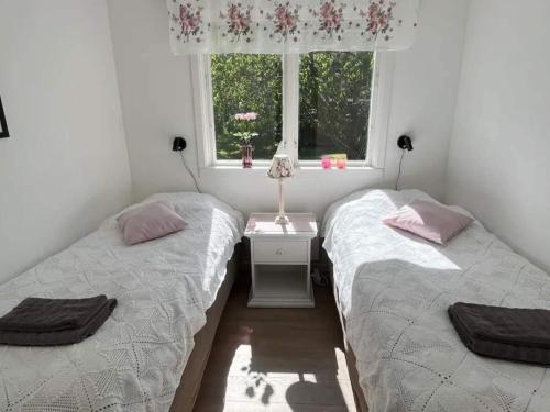 two twin beds in a room with a window at 5 star holiday home in MOLLÖSUND in Mollösund