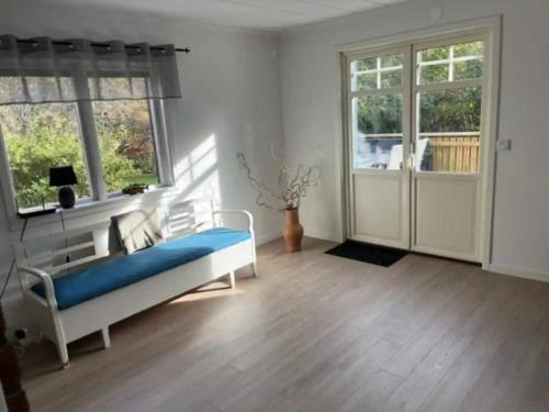 a bedroom with a blue bed in a room with windows at 5 star holiday home in MOLLÖSUND in Mollösund