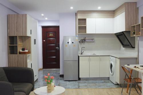 eine kleine Küche mit Kühlschrank und Tisch in der Unterkunft suansuan Apartment in Chengdu