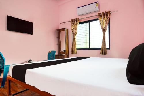 a bedroom with a bed and a window at Hotel O Madhur Inn in Rāipur
