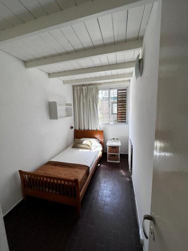 una piccola camera da letto con un letto e una finestra di Duplex Mardifiore Pinamar a Pinamar