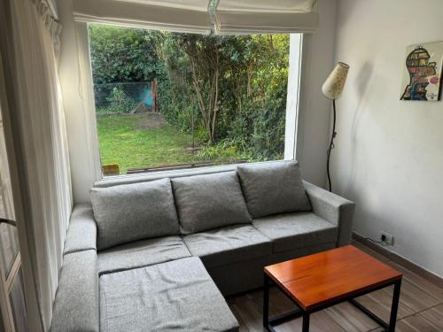 un soggiorno con un divano e una finestra di Duplex Mardifiore Pinamar a Pinamar