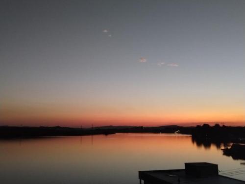 a sunset over a body of water at Casa de Charme Camargos in São João del Rei