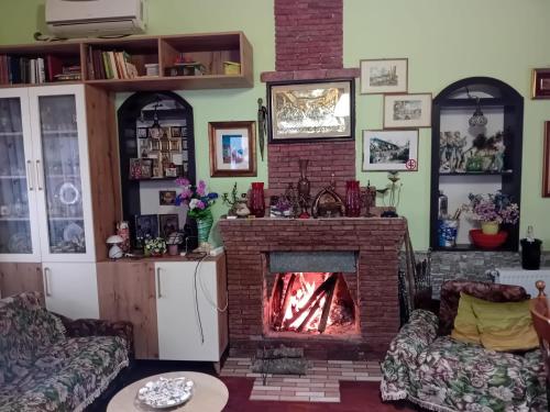 a living room with a brick fireplace with a fire at Ruska's Guesthouse in Kveda-Bashi