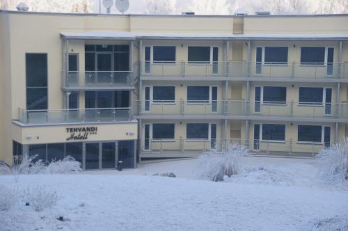 an apartment building with snow in front of it at Tehvandi Hotell in Otepää