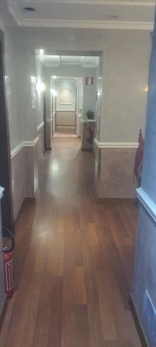 an empty hallway in a building with a wooden floor at Sandel Giubileo Hotel in Rome