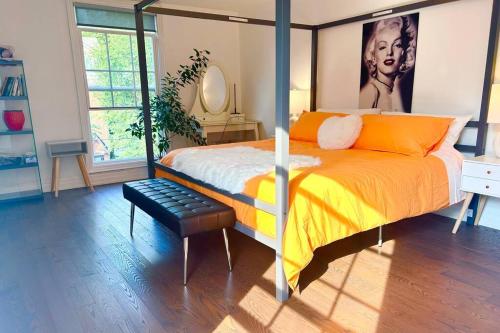 a bedroom with a bed with orange pillows and a mirror at Central Toronto in Toronto